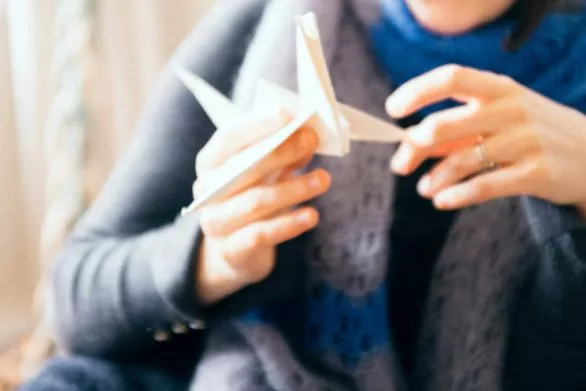 Origami bird in hands