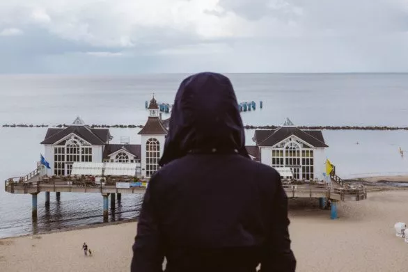 Tourist in rain coat looking at Sellin Pier