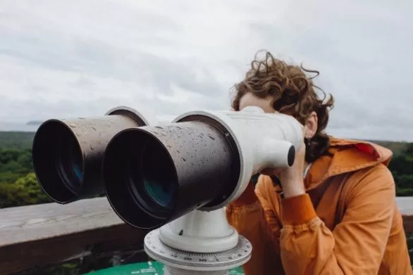 Girl looking in touristic binoculars