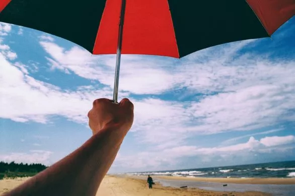 Umbrella in hand on a beach