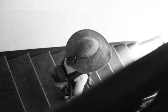 A girl in hat goes down the stairs