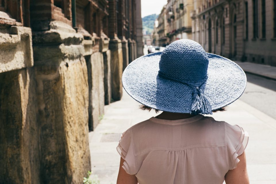 Girl in blue hat on the streets of Turin, Italy