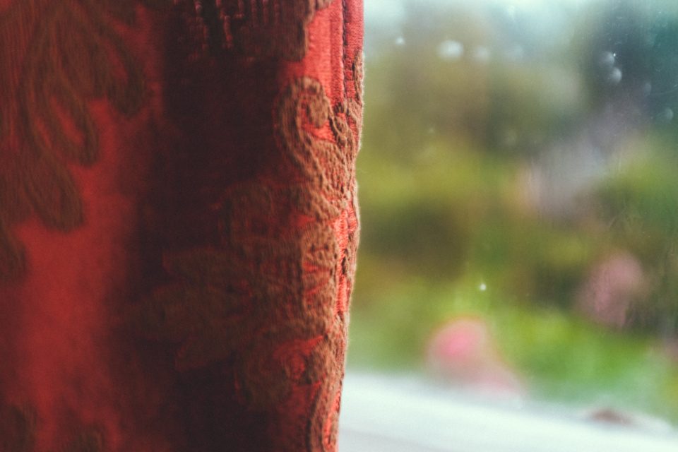 Old red curtain and blurry window