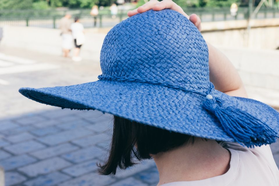 Girl holds her blue hat