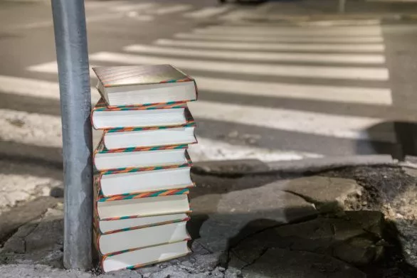 Stack of books on asphalt in the city