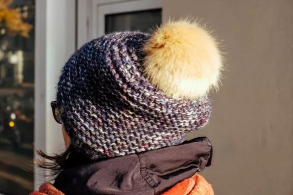 a young woman in a warm hat with a pompom