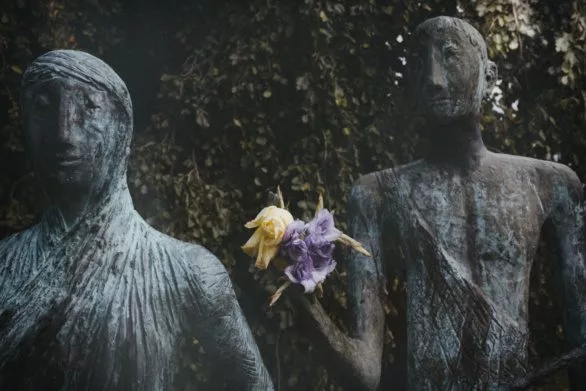 Living flowers in the hands of a sculpture