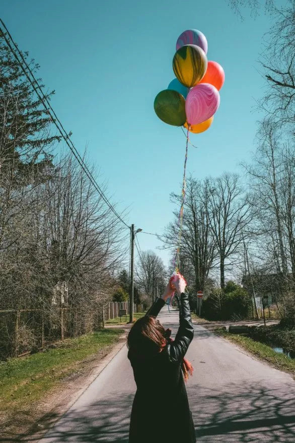 young woman with the colored balloons in her hands