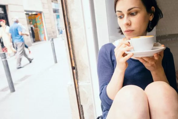 A girl enjoys a cappuccino in a cafe
