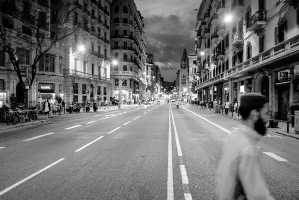 A man crosses the road in Barcelona at night