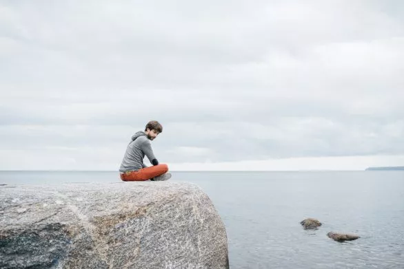 Guy on a rock near the sea