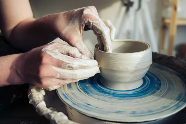 Ceramic artist working on throwing wheel