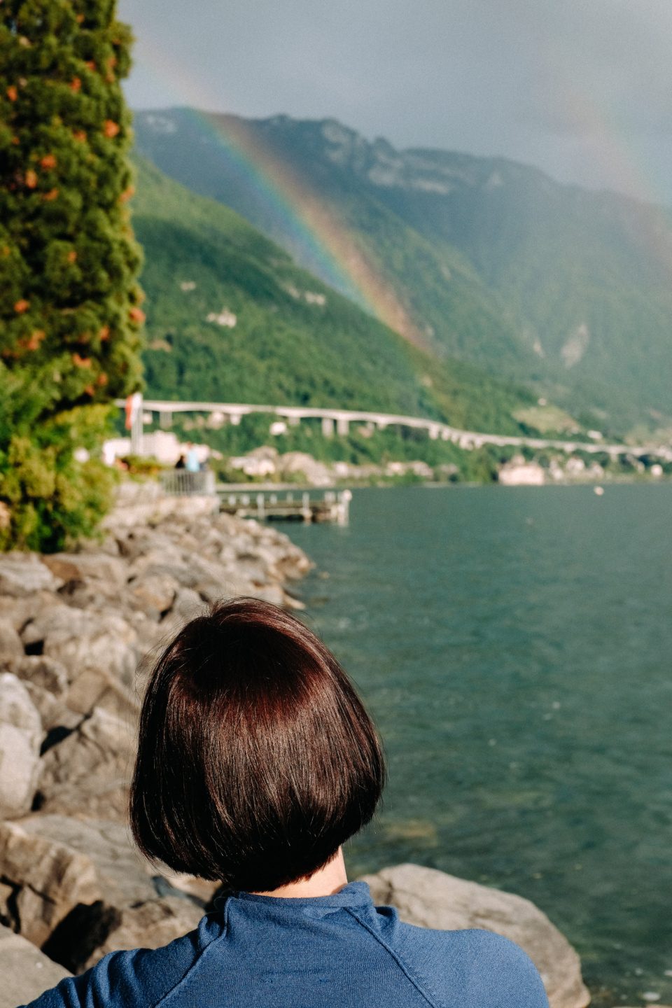 A young woman looking at a rainbow in Montreux, Switzerland