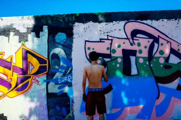 Graffiti artist paints on the Berlin wall