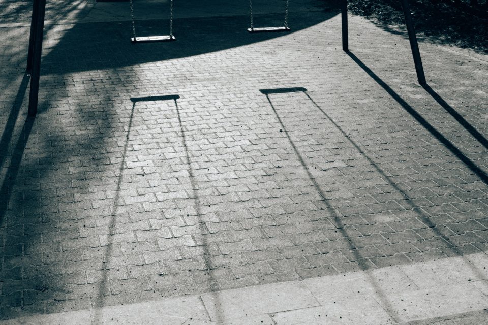 Shadow from swings on paving stone