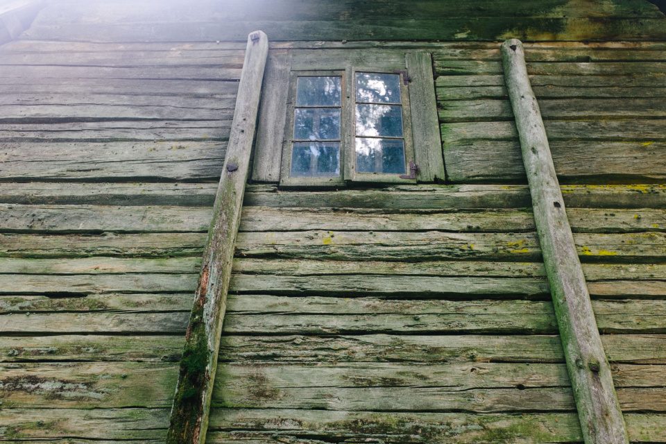 A wall of an old barn with a window