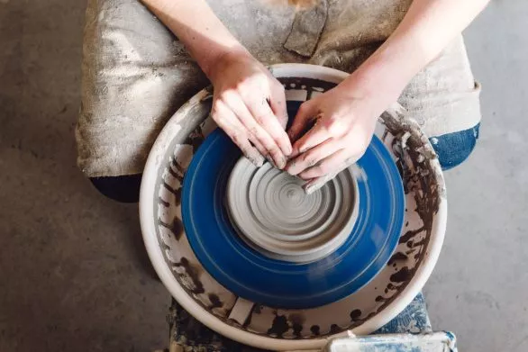 Ceramist's hands at the potter's wheel