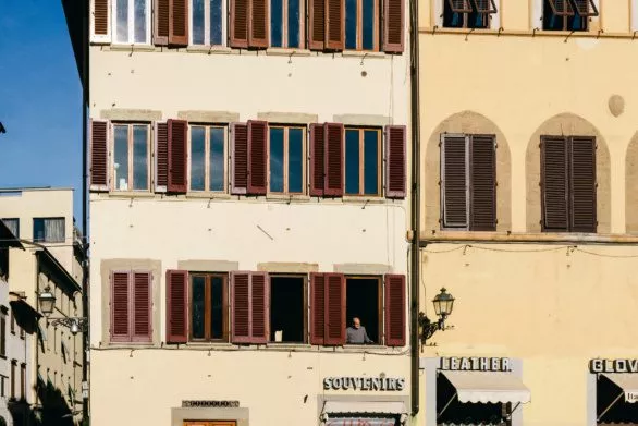 A person looks out of the window in Florence, Italy