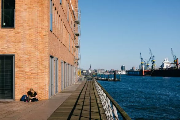 Woman chilling with a book on a quay of the port of Hamburg