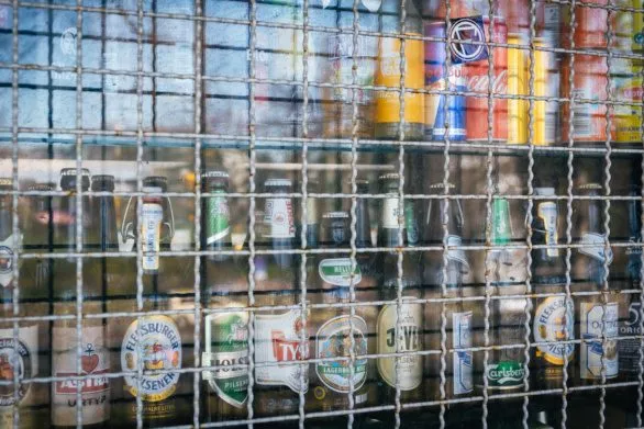 Beer bottles and soft drink cans in kiosk window