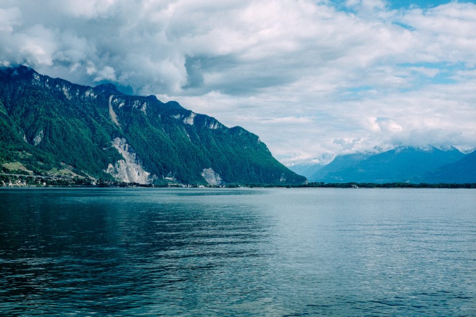 Lake Geneva with clouds above the mountains