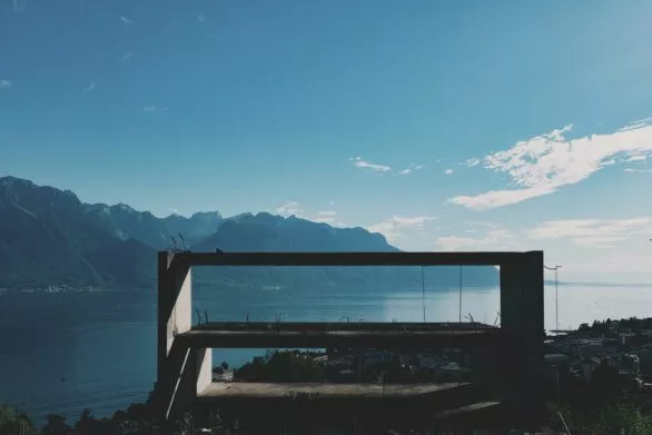 Frame of unfinished building in front of Lake Geneva