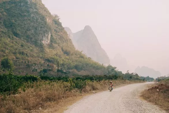 Motorcyclist on a country road near Yangshuo, China