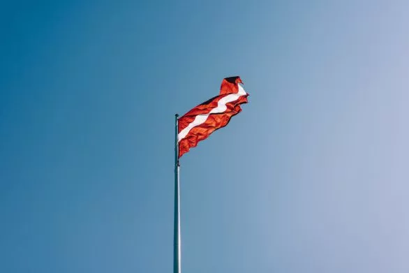 Latvian flag against a blue sky