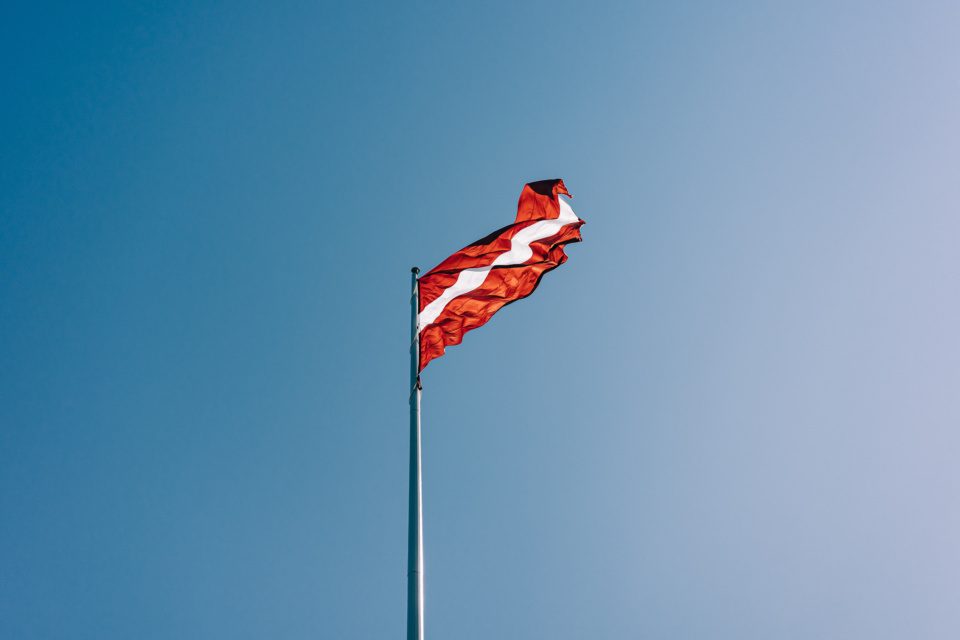 Latvian flag against a blue sky