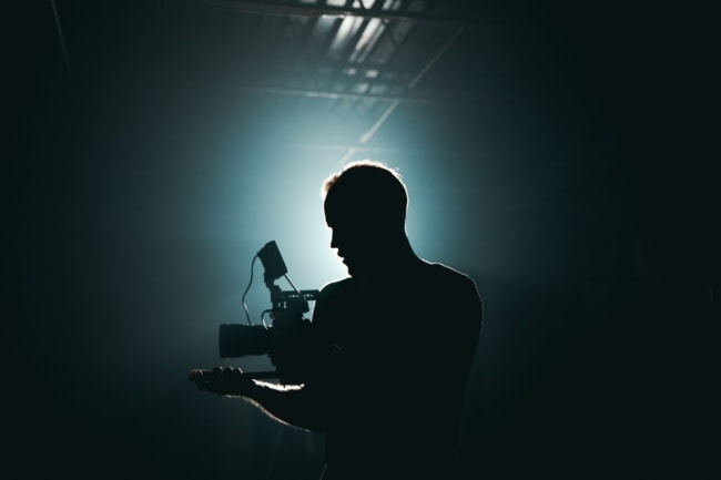 silhouette photograph of man holding camera