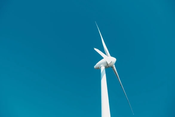 A wind turbine against the blue sky
