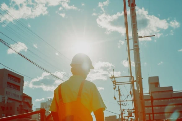 Construction Worker Overseeing Urban Development Under Bright Su