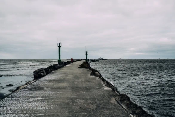 A solitary figure on a concrete pier