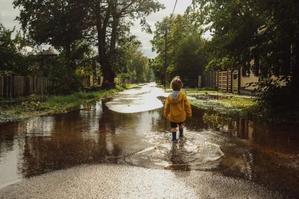 Child Exploring a Flooded Street
