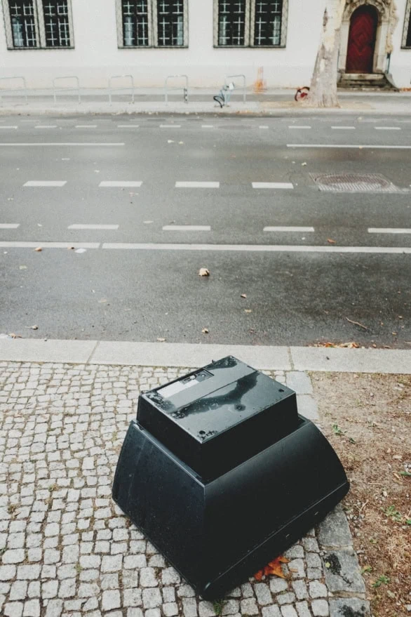 Discarded TV on Cobblestone Sidewalk