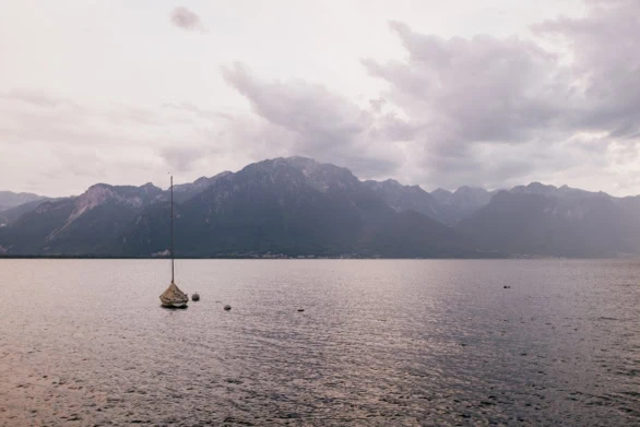 Solitary Sailboat on Lake Geneva with Dramatic Alpine Backdrop a