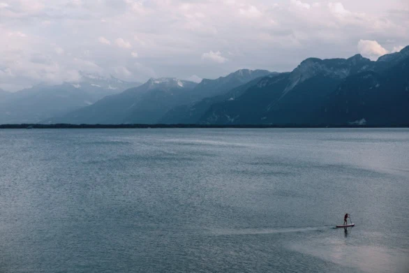 Stand-Up Paddle Boarder on Lake Geneva with Swiss Alps in the Ba