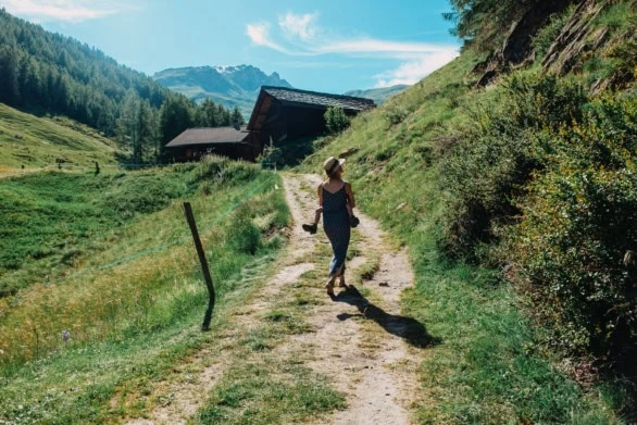 Mother Carrying Child Along Scenic Mountain Path in the Swiss Al