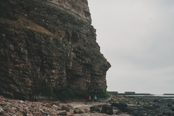 People walking beneath towering cliffs on Heligoland island
