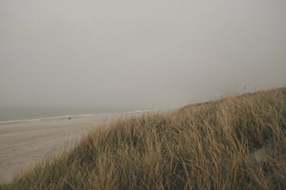 Sand dunes and beach on Sylt Island under a foggy sky