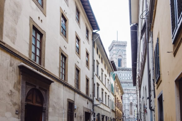 Narrow street in Florence with Florence Cathedral tower, Italy