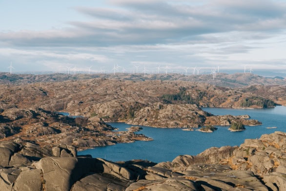 Wind mills over rocks and lake in Norway landscape
